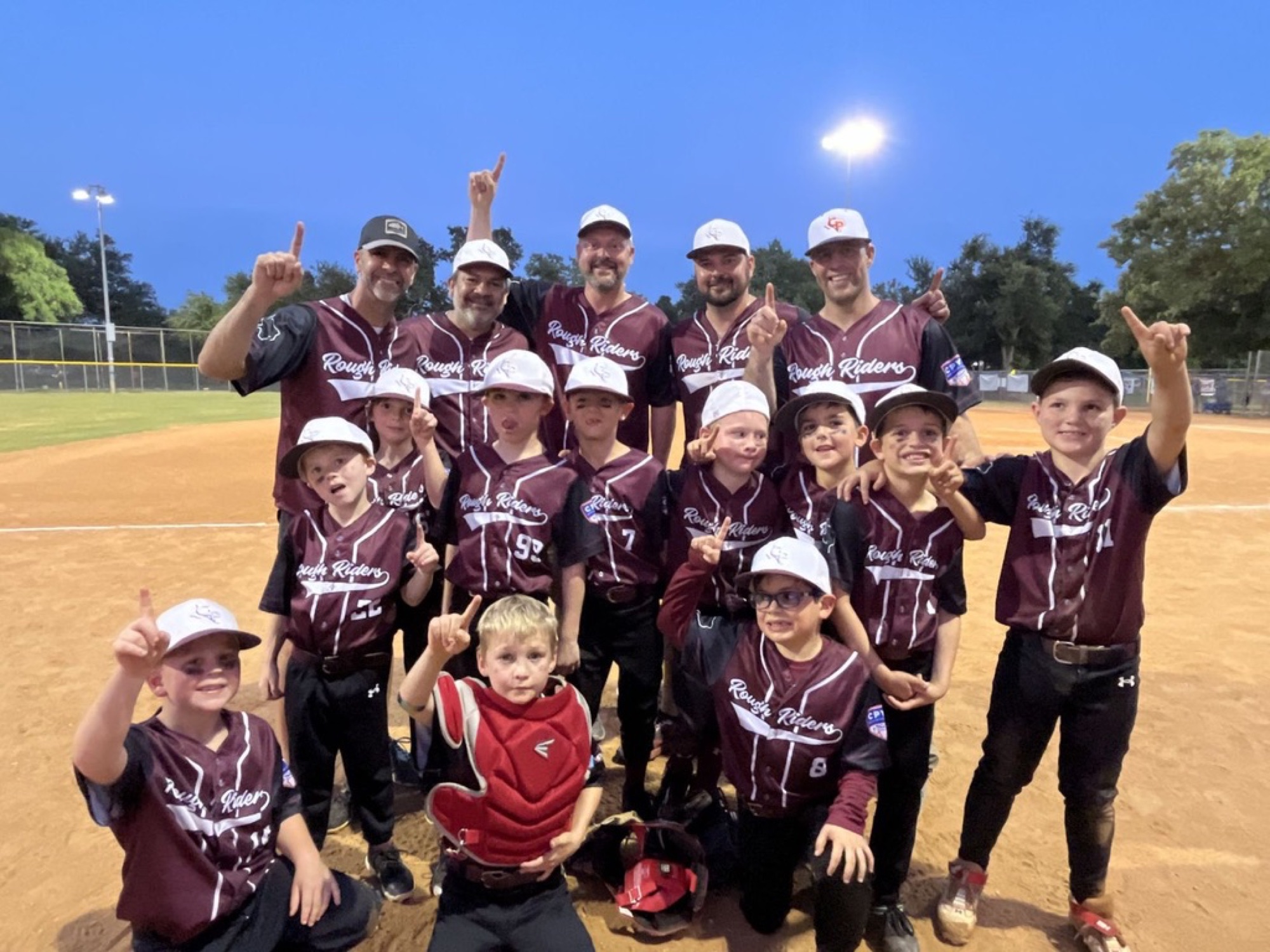 Rough Riders baseball players and coaches celebrating together after a game