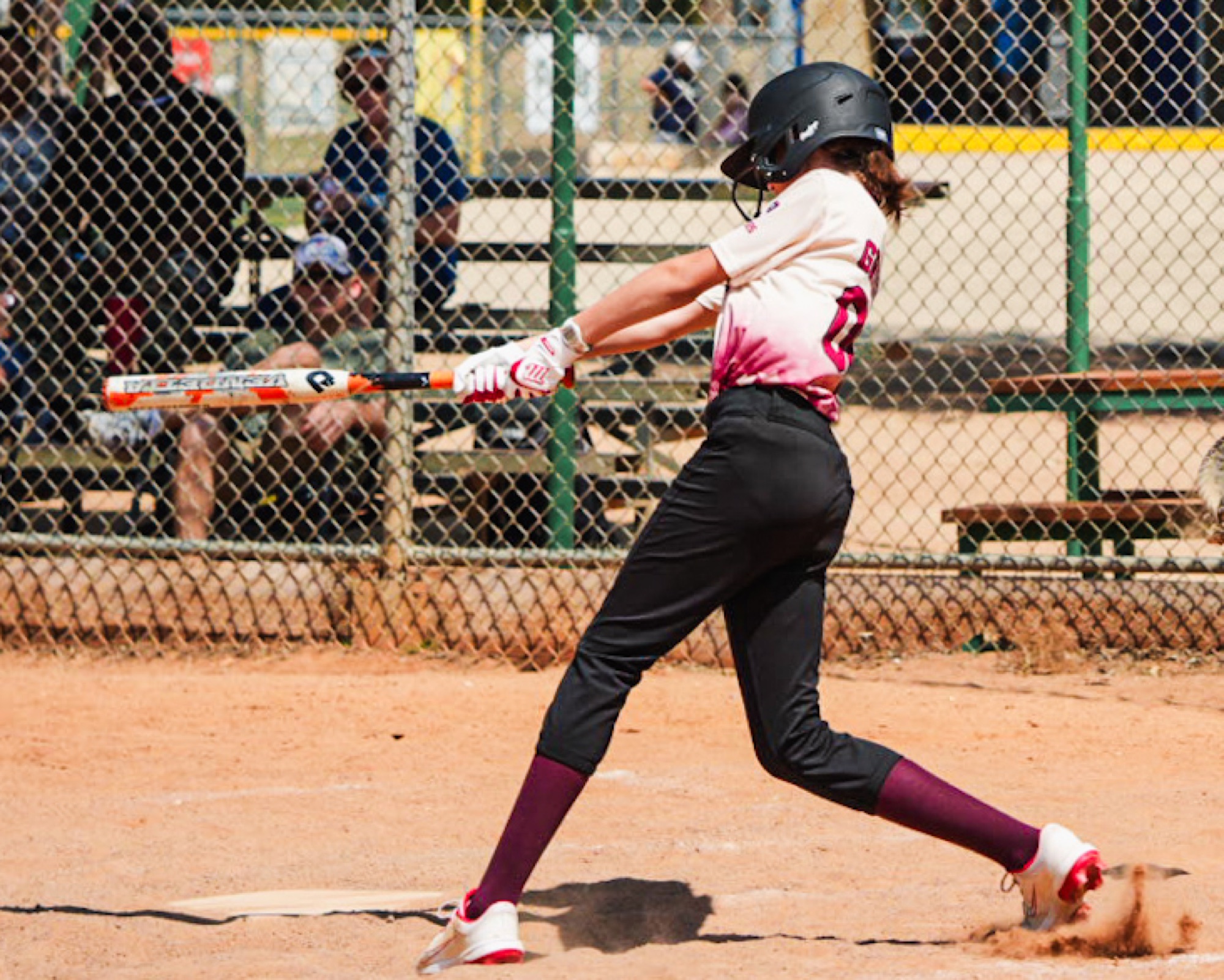 Rough Rider Youth softball player driving the ball at the plate