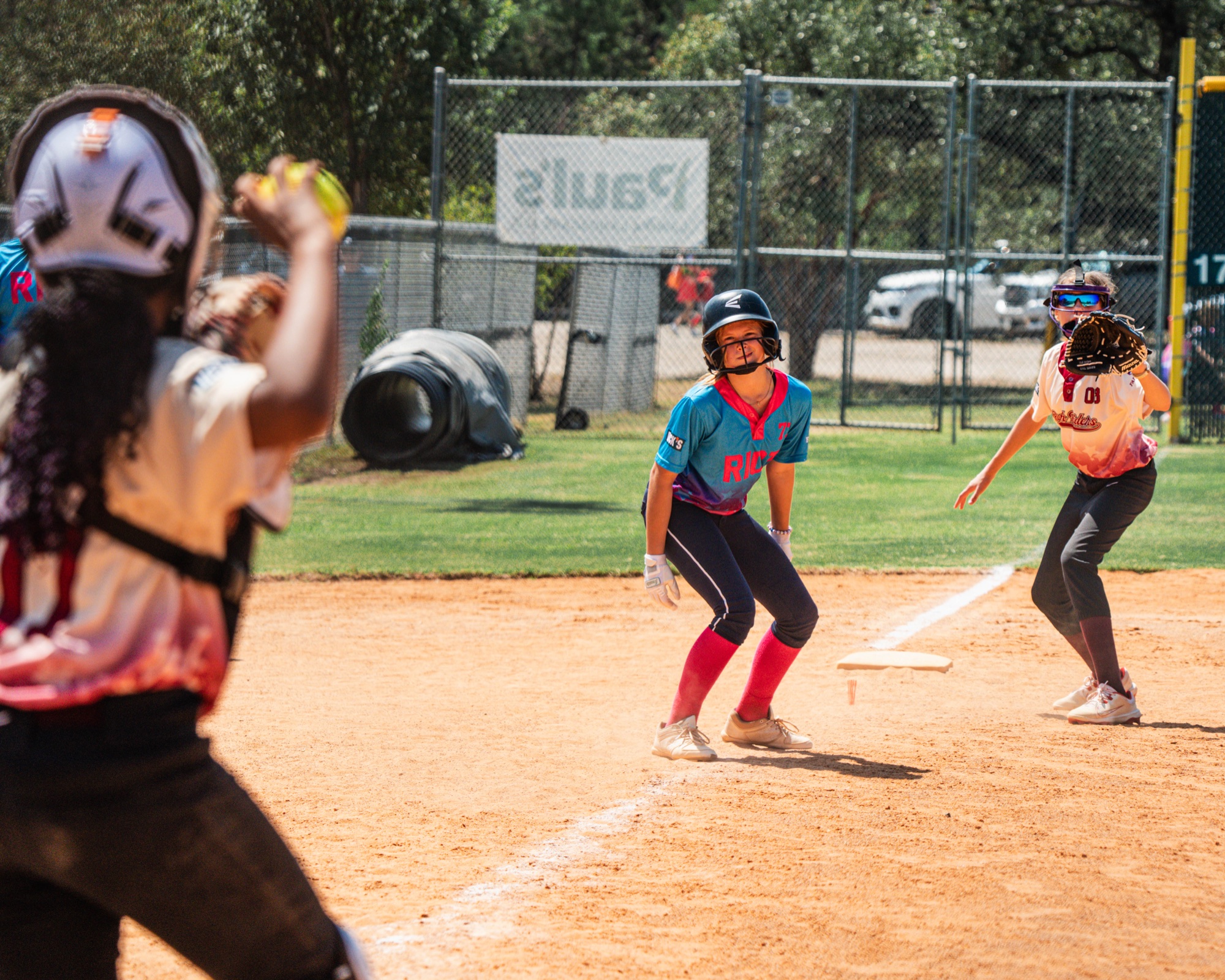 Softball players reacting during a rundown play