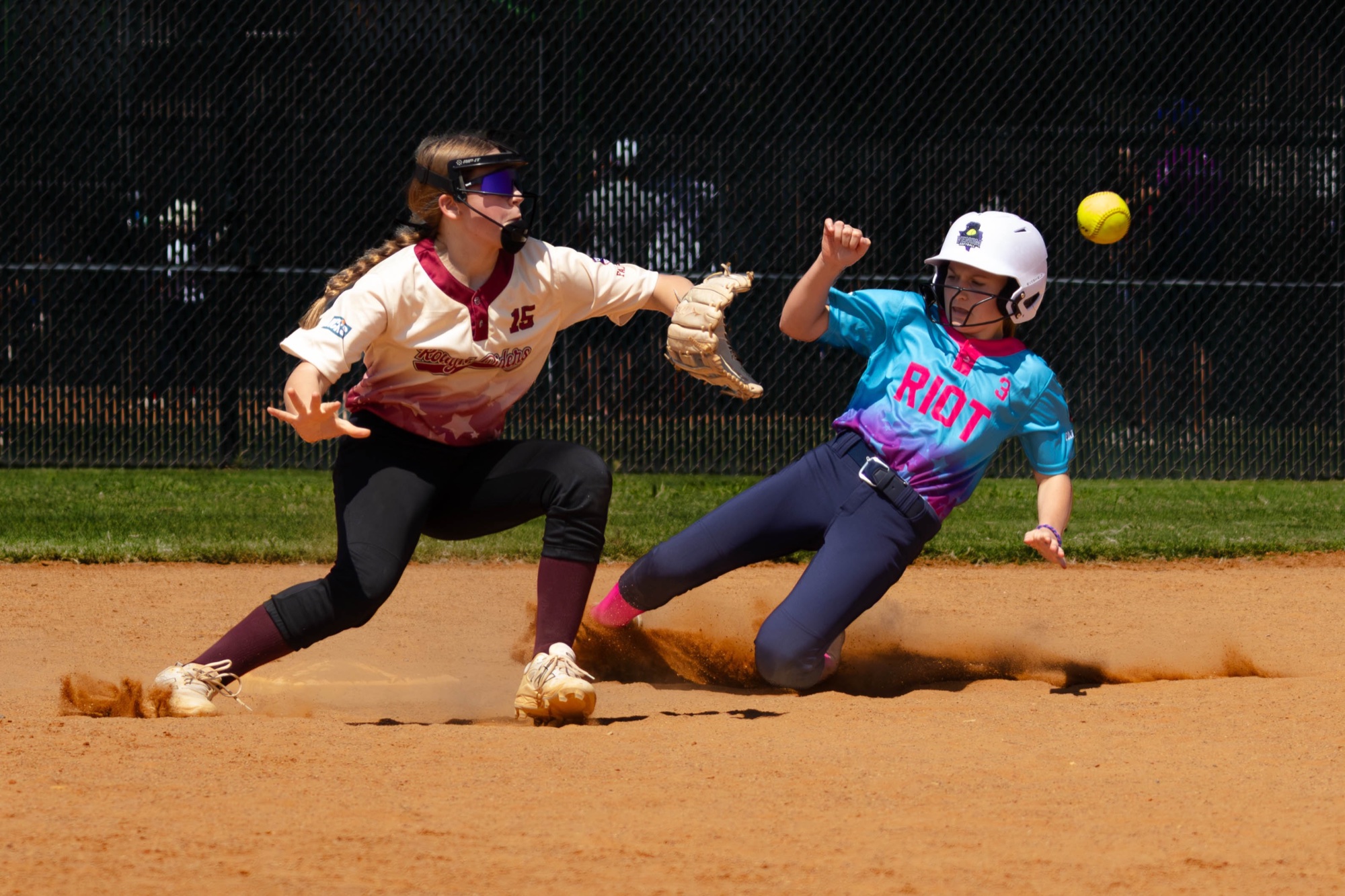 Softball player applying a tag during a slide at second base