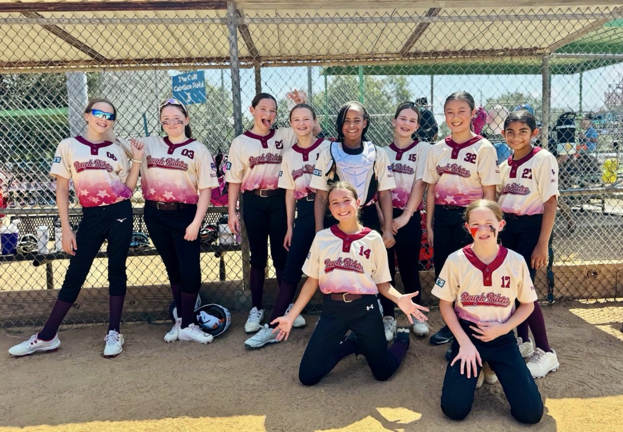 Rough Rider Youth softball players together at the dugout